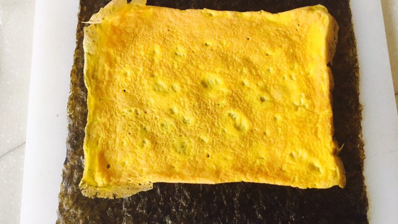 油条寿司卷,铺上一层蛋皮。做蛋皮时，不放玉米青豆也可以。