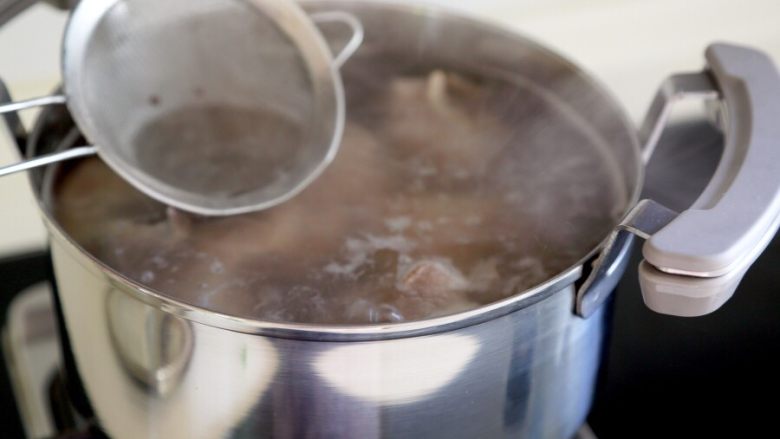 玉米大骨汤,3.将清洗干净猪大骨头再次入锅，并倒满一锅清水，大火烧开后撇去浮沫。