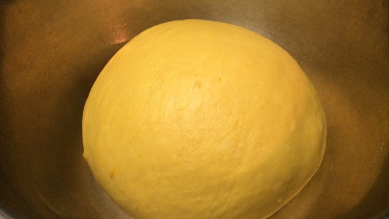 南瓜蜜豆肉松包,把揉好的面团搓圆，放入盆中，盖上保鲜膜放温室进行第一次发酵。