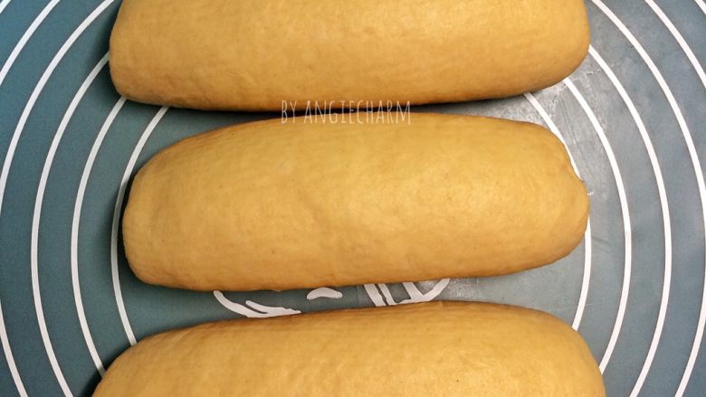 汤种炼乳黄豆粉面包,每个小面团擀成长椭圆形，挤出旁边的小气泡，卷起，收口向下，盖保鲜膜放松一刻钟。