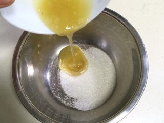 蜂蜜无水蛋糕,在打蛋器盆内加入细砂糖和蜂蜜。
