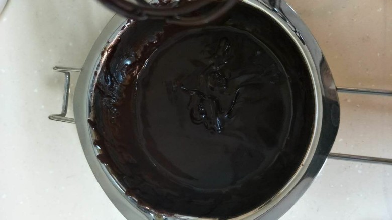 焦糖巧克力戚风蛋糕,离火后趁热加入黑巧克力搅拌均匀使巧克力融化