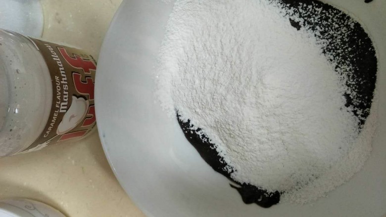焦糖巧克力戚风蛋糕,趁热加入过筛的低筋面粉，搅拌均匀