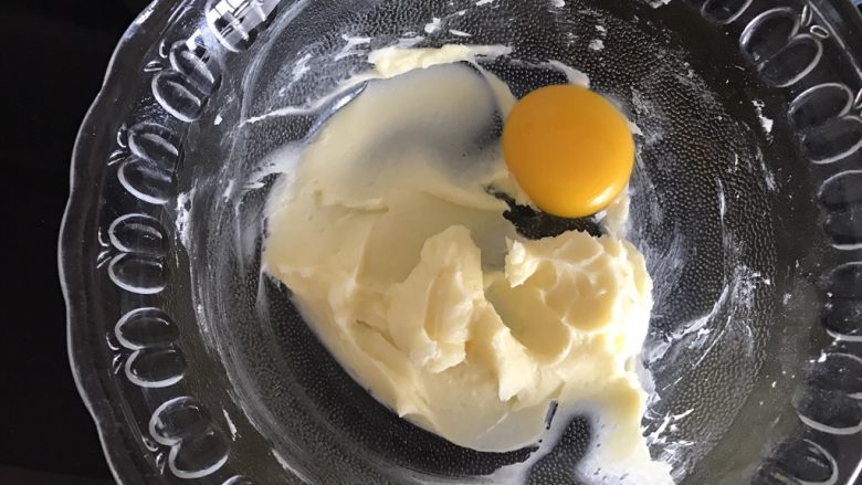 小乌龟菠萝包,翻拌均匀的黄油加入一个蛋黄，开动电动打蛋器低速打发。