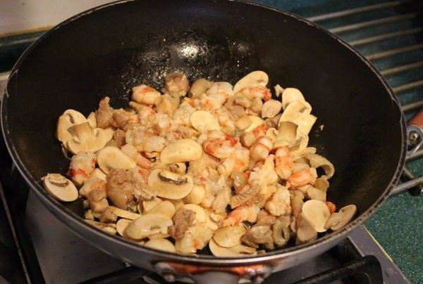 法式咸派 QUICHE,依序将切丁的鸡腿肉、鲜虾、蘑菇片放入锅内炒至略熟。加盐、胡椒、七味粉调味。