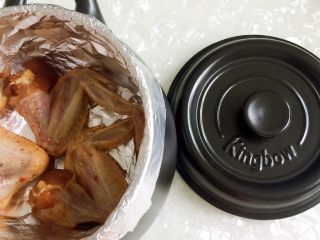 坤博砂锅之烤鸡翅,把鸡翅放入锅内(一次只能烤三个)，盖上盖子放上灶