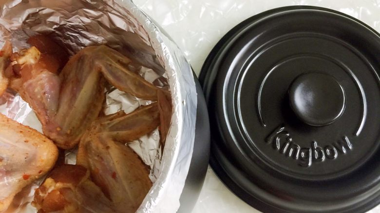 坤博砂锅之烤鸡翅,把鸡翅放入锅内(一次只能烤三个)，盖上盖子放上灶
