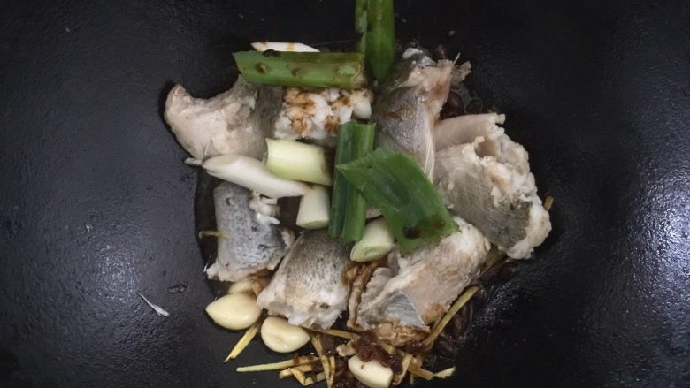 酱烧海鲈鱼,下葱段，倒入调料汁，等待一分钟，使其香味充分散发出来。
