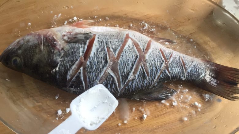 糖醋鲈鱼,然后在鱼身上抹上淀粉。（煎鱼时防粘锅）