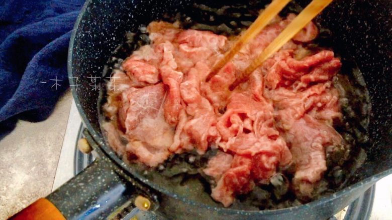 铁板孜然牛肉,待炸油条的油温降至五六成热时，将腌制好的牛肉下入，快速滑熟捞出