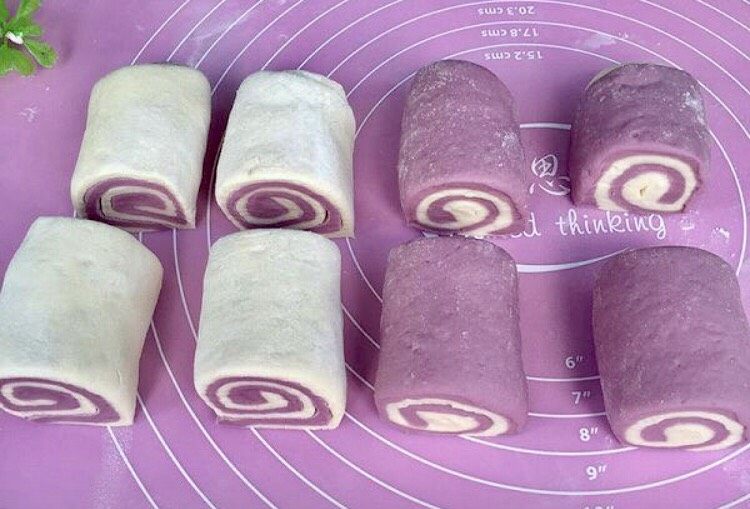 双色紫薯馒头,用锋利的刀切均等的卷卷，盖上保鲜膜二次发酵15-20分钟即可