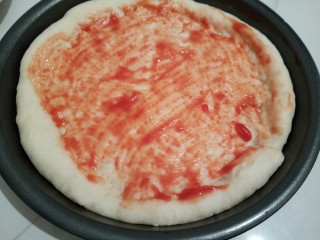 自制火腿肠披萨,烤了5分钟以后，拿出来刷适量的番茄酱（喜欢番茄酱的可以做刷一点，）