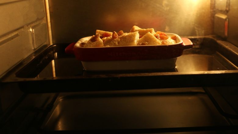 英式面包布丁,
放入烤箱中层，180度烤30分钟至布丁液凝结，表面呈现金黄色后即可出炉