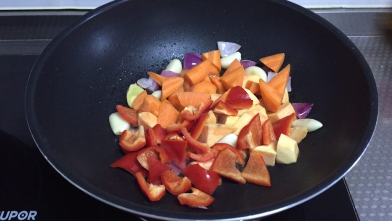 翅根焖锅,倒入红薯，红萝卜和红椒翻炒
