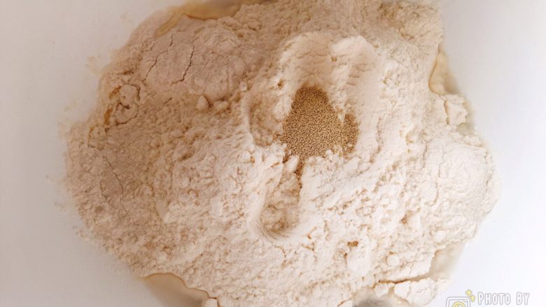 软绵绵的黑芝麻炼乳吐司,提前一天准备中种面团：
依次倒入冰水、面包粉、干酵母，和成团。