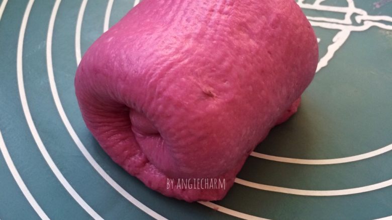 梦幻粉嫩系紫薯芝士面包,离自己近的一头稍压扁，自远往近卷起不超过2.5圈。三个面团同样擀卷好，收口向下排进模具。