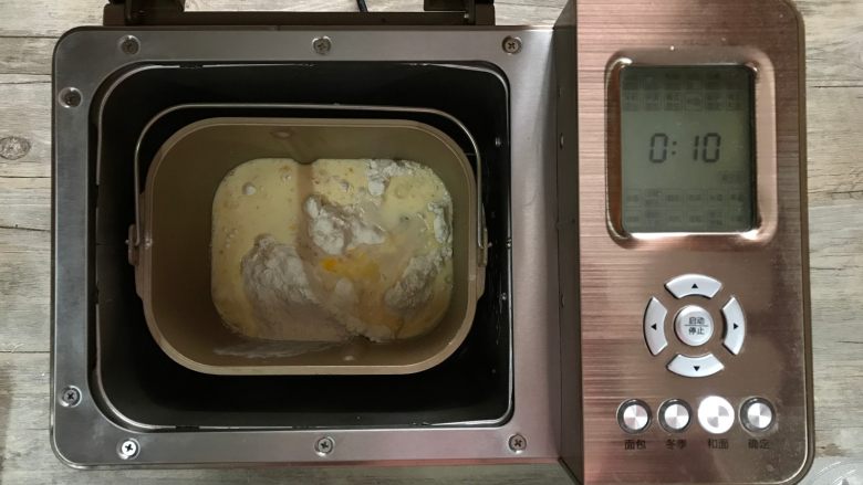 芝麻软面包,依次将粉类、液体类、及酵母水倒入面包机内，设置和面10分钟。