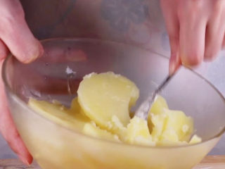 土豆饼的家常做法，吃起来特别过瘾,将蒸号的土豆装盘用勺子压成土豆泥。
