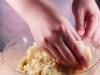 土豆饼的家常做法，吃起来特别过瘾,将拌号的土豆泥用手压成饼状。