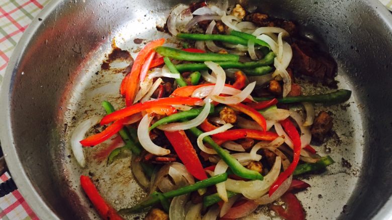 “黑胡椒培根牛肉粒意面”,然后加入洋葱丝和彩椒丝一起翻炒几下。