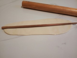 香菇肉丝宽面,醒发好的面团，擀面杖擀成长条形，用筷子在面条中间压一下，压出一个痕迹，方便撕开，
