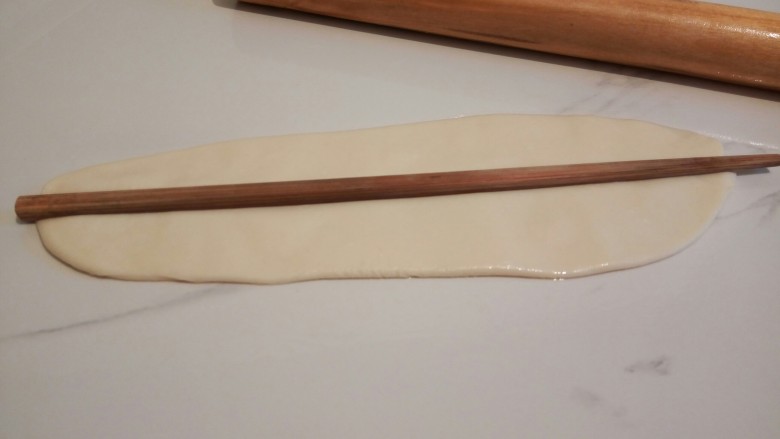香菇肉丝宽面,醒发好的面团，擀面杖擀成长条形，用筷子在面条中间压一下，压出一个痕迹，方便撕开，