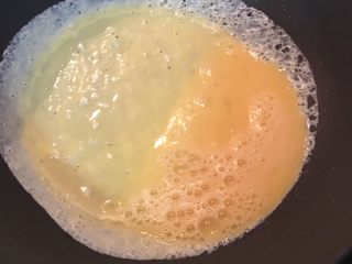 蛋包蕃茄炒饭,不沾锅中抹少许油,锅子微热后倒入一半的蛋液,并马上离火转锅子,让蛋液均匀的附着在锅子上,