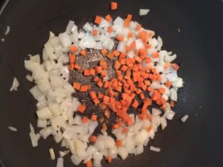 蛋包蕃茄炒饭,炒锅中放入少量的油,炒香洋葱后放入红萝卜丁略炒