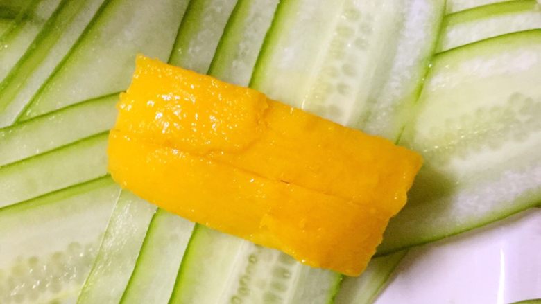 夏日冰爽黄瓜芒果卷,将两根芒果条放在一组黄瓜皮上
