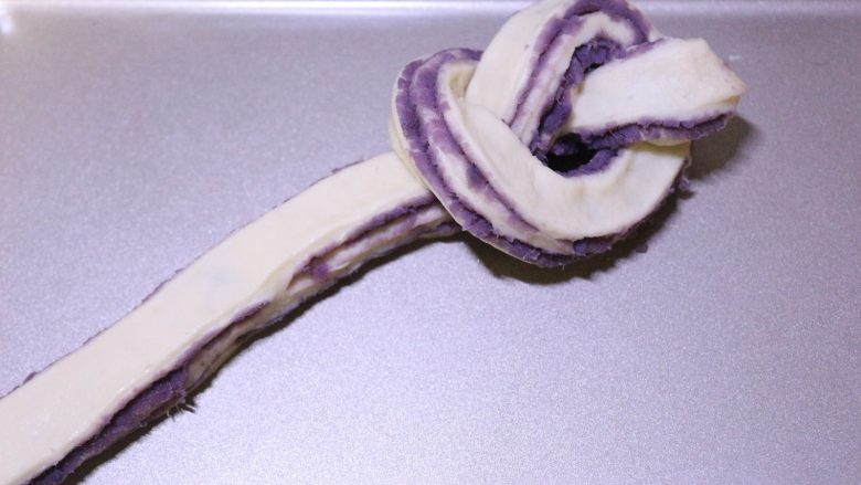 汤种紫薯花卷面包,取一条面团，将一端打结
