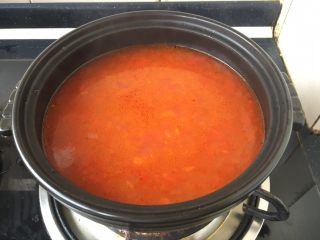 番茄金针菇肥牛,取一个砂锅，放在炉灶上开大火，在砂锅里放入适量的番茄汤。