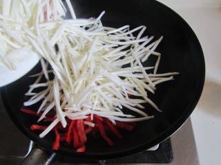 茭白鳝鱼丝, 热锅凉油，放入茭白丝和红椒丝进去煸炒；