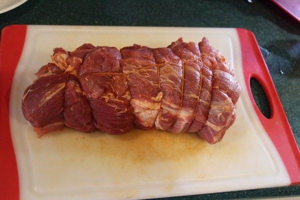 拿铁炙猪肉,用棉绳将肉捆好。捆肉可以防止烹煮过程肉块散形，保住漂亮的外型和丰富的汁液。