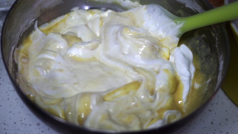 低糖柔软细腻的香蕉戚风,挖取三分之一的蛋白到蛋黄糊里面，翻拌均匀。
拌之前检查一下蛋白状态，如果稍微有点消泡，可以再打几下，恢复状态。