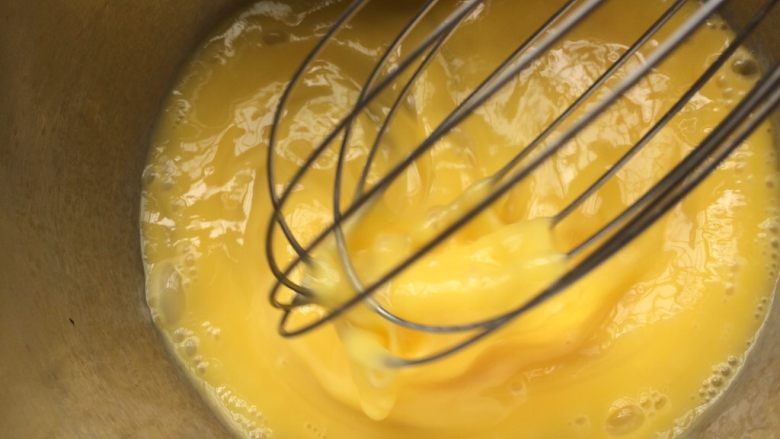 牛奶焦糖布丁,用手动打蛋器把鸡蛋打散搅拌至蛋清蛋黄混合均匀。