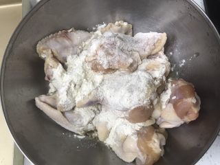 在家也能做的香烤鸡翅,拿夹子夹取鸡翅，粘好香酥鸡翅料，两面沾匀。