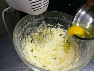 无人不爱的法式磅蛋糕,打至黄油饱含空气颜色接近白色，分次加入蛋液。黄油和鸡蛋充分融合，蛋液完全吸收，再加二次蛋液，继续低速打匀。每一次都要充分拌匀至黄油糊细腻光滑状。