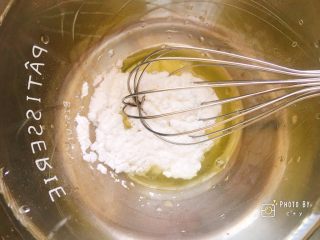 香浓诱人的椰香岩饼,蛋清中加入糖粉，用蛋抽搅拌均匀。