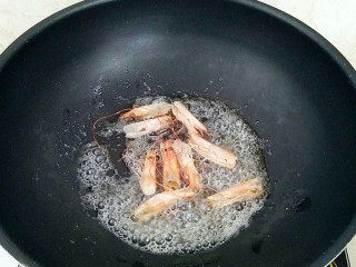 鲜虾菌菇面,锅中放油，烧热放入虾头炒出虾油，捡出虾头。