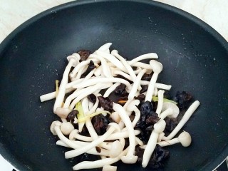 鲜虾菌菇面,放入木耳和白玉菇，胡椒粉，味精翻炒均匀。