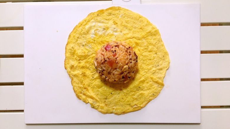 茄汁mini蛋包饭,取一张蛋皮，包入适量捏紧成饭团的茄汁炒饭。