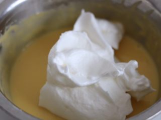 芒果多多奶油盒子蛋糕,6.取三分之一的蛋白霜放入蛋黄糊中切拌均匀
