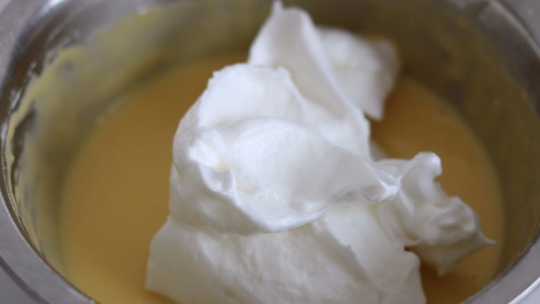 芒果多多奶油盒子蛋糕,6.取三分之一的蛋白霜放入蛋黄糊中切拌均匀
