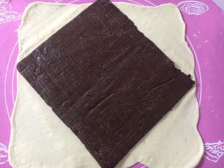 黑巧克力大理石吐司,擀成大大的面皮，取出巧克力片放在居中