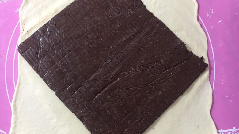 黑巧克力大理石吐司,擀成大大的面皮，取出巧克力片放在居中