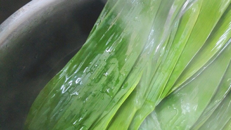 彩米花生香菇肉粽,最后再用热水冲洗，这样洗干净了，粽叶经过高温包时不易裂开。