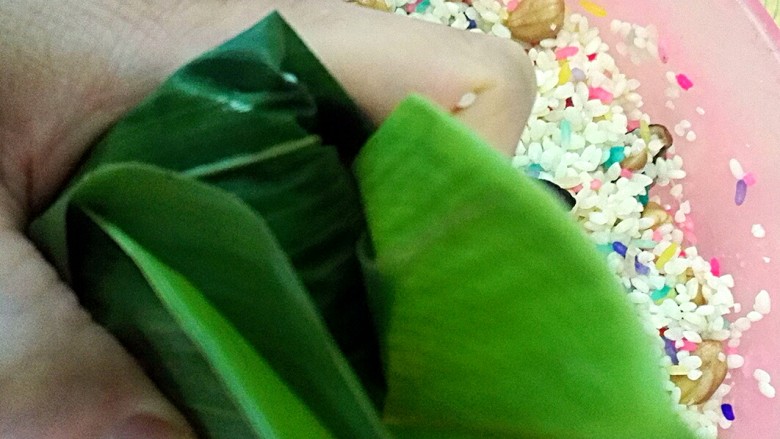 彩米花生香菇肉粽,多余的粽叶往边上折