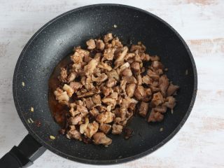 酱爆羊肉,继续翻炒，使每一块羊肉都均匀的裹上酱料。