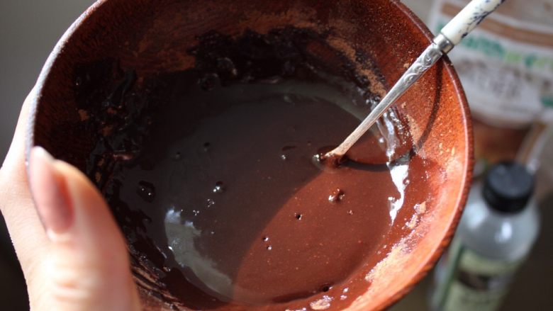 （不用烤箱)迷你巧克力果仁蛋糕,在一个碗里，搅拌25ml椰子油，15ml蜂蜜还有20ml可可粉