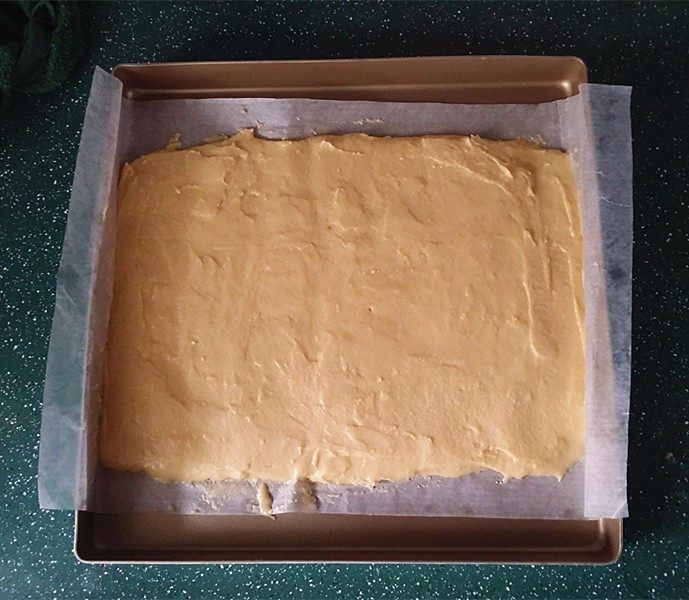 西番尼蛋糕,倒入铺有油纸的烤盘中抹平